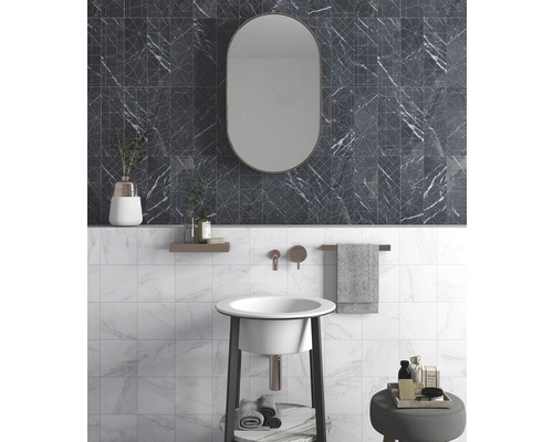 Badezimmer mit schwarzem Marmorfliesenmuster, Spiegel und Waschtisch