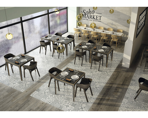 Innenaufnahme eines Restaurants mit Tischen, Stühlen und Bodenfliesen in gemustertem Design.