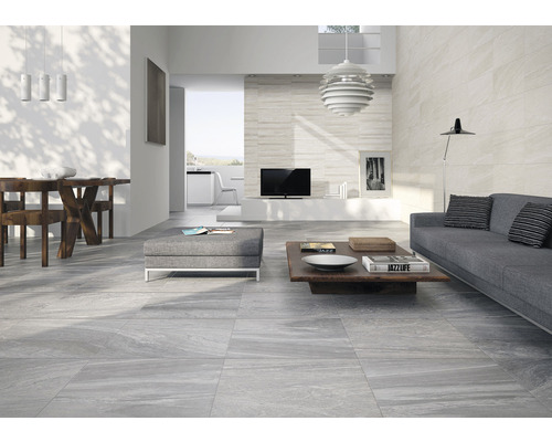 Helles Wohnzimmer mit grauen Bodenfliesen, Sofa und Holztisch