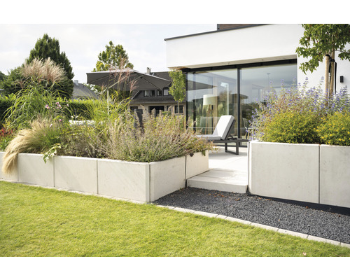 Garten mit Rasenfläche, Hochbeeten aus Beton und Sitzbereich