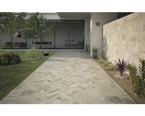 Extérieur avec carrelage de sol imitation pierre et motif décoratif à chevrons sur un chemin de jardin.