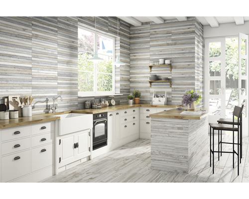 Cuisine lumineuse avec parquet et carrelage mural imitation bois, plan de travail en bois, îlot de cuisine et tabourets de bar.