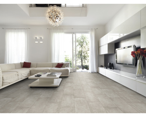 Salon lumineux avec carrelage, canapé, table et télévision