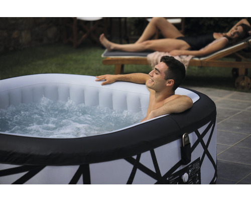Aufblasbarer Whirlpool im Garten mit entspannendem Mann im Wasser