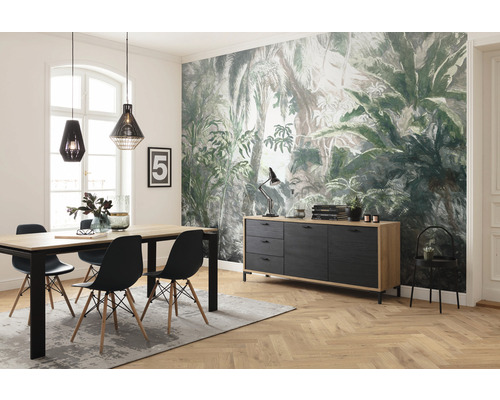 Salle à manger avec table à manger, chaises, buffet et décoration devant un papier peint jungle.