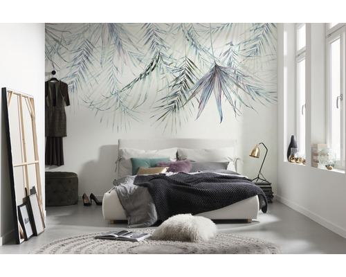 Schlafzimmer mit einem Bett, einem Teppich und einer Wandtapete mit Blättern