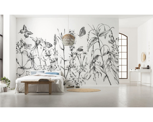 Chambre spacieuse avec papier peint photo floral, lit et lampe tressée