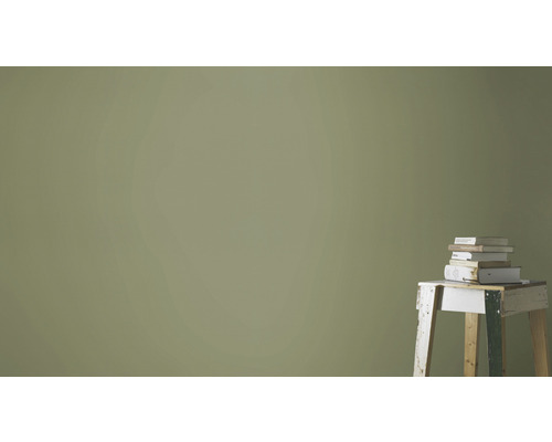 Wand mit Farbanstrich und Stapel Bücher auf einem Hocker
