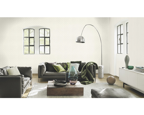 Salon avec canapé, fauteuil, lampadaire et papier peint à motifs pour une ambiance élégante