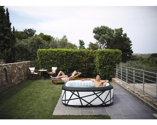 Aufblasbarer Whirlpool im Garten mit entspannten Personen auf Liegestuhl und im Wasser.