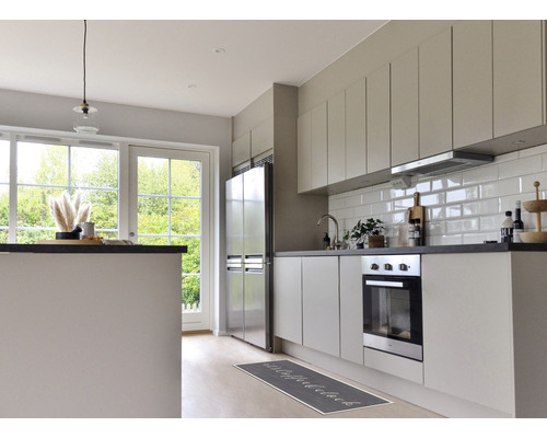 Helle Küche mit Küchenzeile, Spüle, Herd, Kühlschrank und Küchenläufer