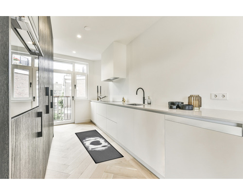 Cuisine moderne avec tapis de cuisine, armoires blanches et plancher en bois