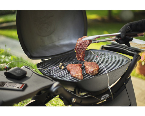 Scène de barbecue avec des steaks sur le gril et une pince à barbecue avec un steak