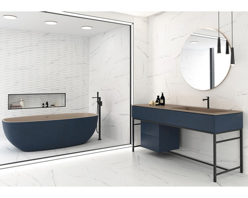 Salle de bains lumineuse avec baignoire autoportante, meuble-lavabo et carrelage grand format aspect marbre