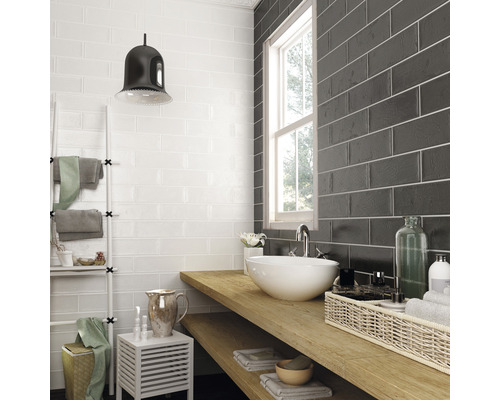 Badezimmer mit weißen und grauen Wandfliesen, Waschbecken und Holzablage