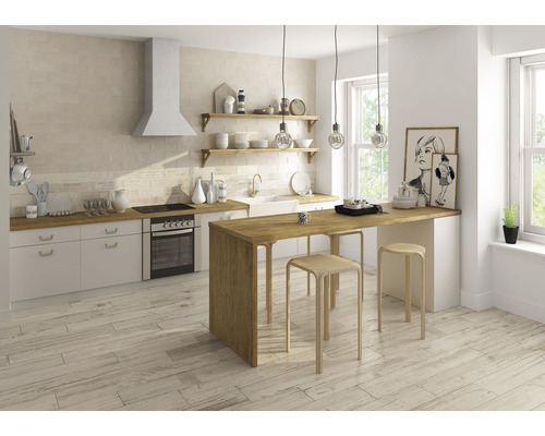 Helle Küche mit Holztisch, Hockern und Plattenboden in Holzoptik.