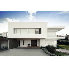 Maison moderne avec allée carrelée grise et design minimaliste.