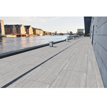 Vue sur une promenade riveraine avec dalles de sol et rigole de drainage