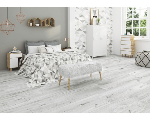 Chambre avec lit, armoire blanche, banc et plancher en bois clair