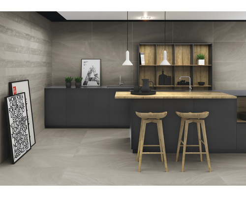 Cuisine moderne avec carrelage gris sur les murs et le sol, armoires foncées et îlot de cuisine avec plan de travail en bois