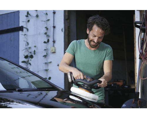 Homme polissant une voiture avec une polisseuse