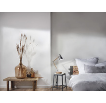 Chambre claire avec lit en bois, lampe de chevet et décoration sur une table en bois
