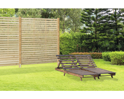 Scène de jardin avec clôture en bois et deux chaises longues en bois sur une pelouse