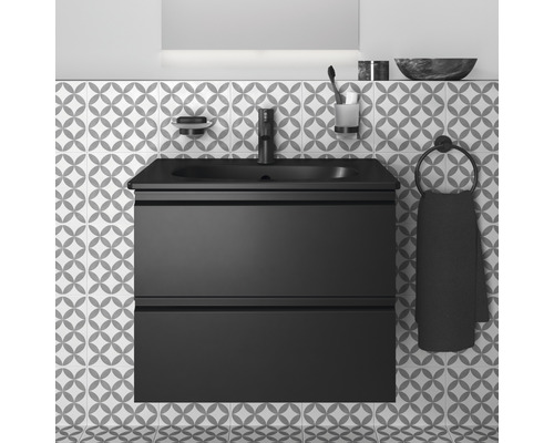 Salle de bains moderne avec meuble sous-vasque, lavabo et robinetterie noirs devant un mur à motifs