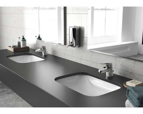 Salle de bains avec double vasque, robinetterie et distributeur de savon