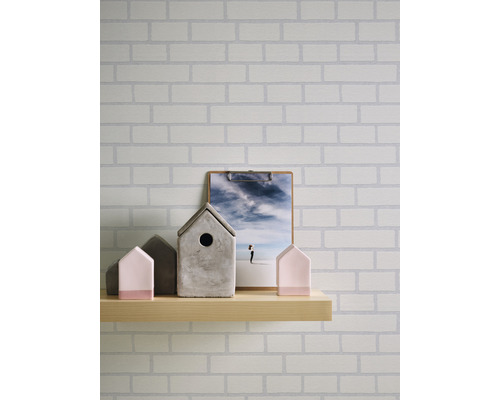 Mur avec papier peint en briques, étagère en bois avec maisons décoratives et image