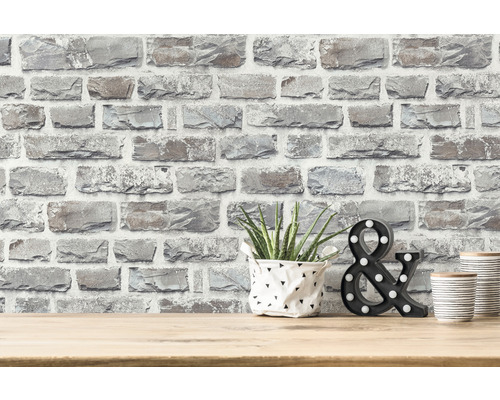 Papier peint décoratif aspect pierre sur un mur avec plante, symbole & décoratif et boîtes décoratives sur une table