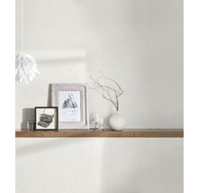 Wohnraum mit Tapete, Regal und dekorativen Elementen wie Bilderrahmen und Vase