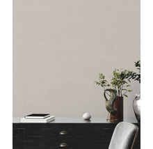 Detailaufnahme einer strukturierten Wandtapete in einem Interieur mit Kommode und Dekoration.