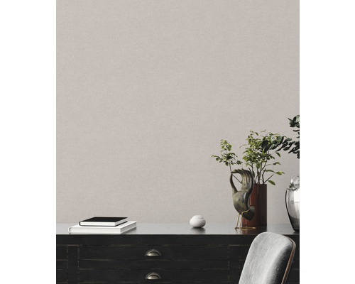 Detailaufnahme einer strukturierten Wandtapete in einem Interieur mit Kommode und Dekoration.