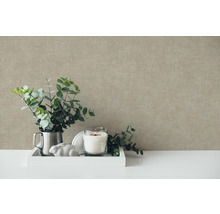 Dekorative Stillleben-Szene mit Eukalyptuszweigen, Kerze und Zierelementen vor einer strukturierten Wand