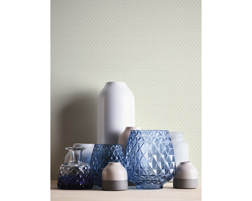 Vases décoratifs sur une table devant un papier peint à motifs