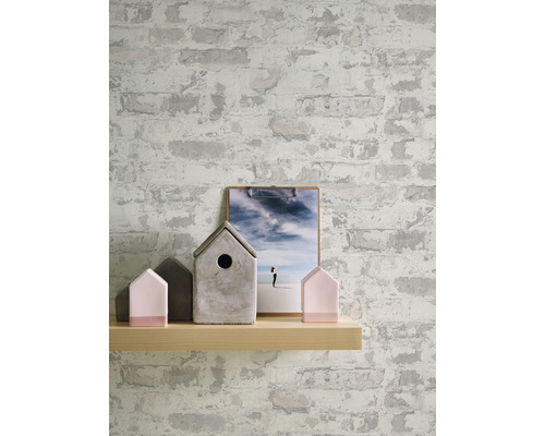 Décoration murale avec papier peint aspect brique, étagère en bois, maisonnettes décoratives et image