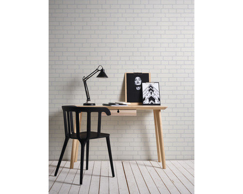 Schreibtisch mit Stuhl, Lampe und Dekoration in einem hellen Raum