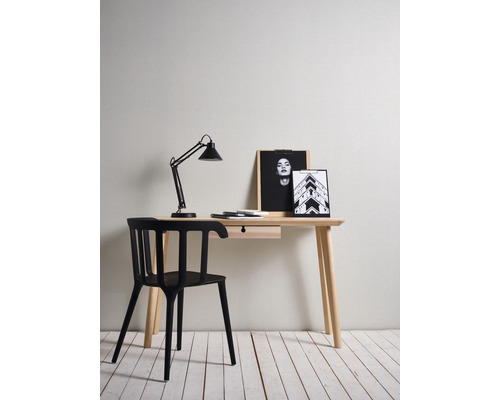 Schreibtisch mit schwarzem Stuhl, Schreibtischlampe und Bildern als Dekoration