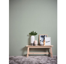 Scène décorative avec vase, tableaux et banc en bois devant un mur