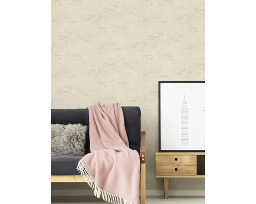 Scène d''intérieur avec papier peint structuré beige clair, canapé, coussin, couverture et commode