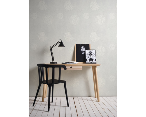 Ein Arbeitszimmer mit einem Schreibtisch, einem Stuhl, einer Lampe und einer gemusterten Tapete.