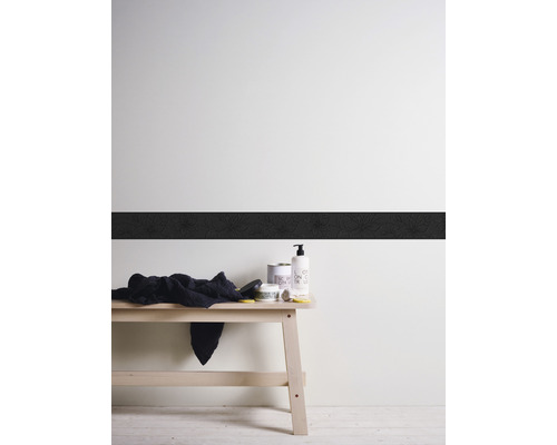 Mur décoratif avec bordure, serviette et produits de soin sur un banc en bois