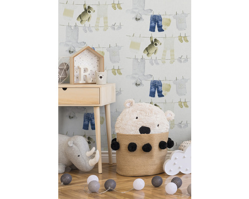 Chambre d''enfant avec papier peint pour enfants, table de chevet, panier ours, jouets et guirlande lumineuse.