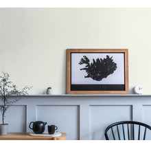 Wohnraum mit Wandgestaltung, gerahmtem Island-Poster und Dekorationen.