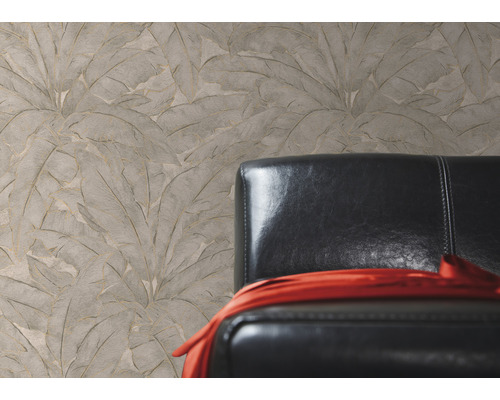 Papier peint beige structuré à motifs de feuilles à côté d''un fauteuil en cuir noir