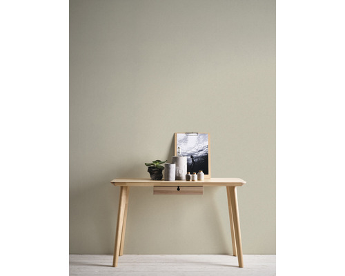 Bureau en bois clair avec tiroir, décoration et image au mur.