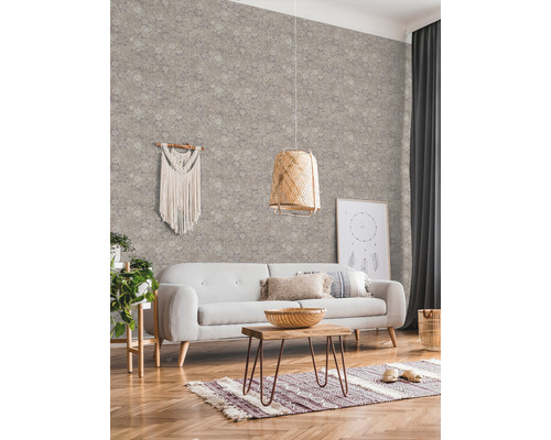 Wohnzimmer mit gemusterter Tapete, Sofa, Tisch und dekorativen Elementen für eine gemütliche Atmosphäre