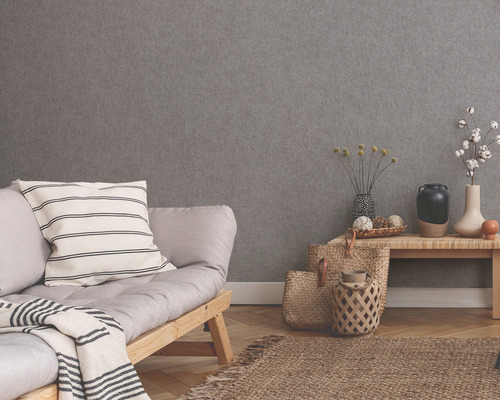 Intérieur avec papier peint structuré gris, canapé, table et décoration