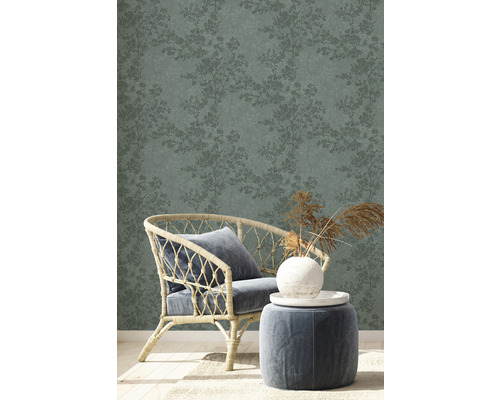 Szene mit floral gemusterter Tapete, Sessel und Hocker